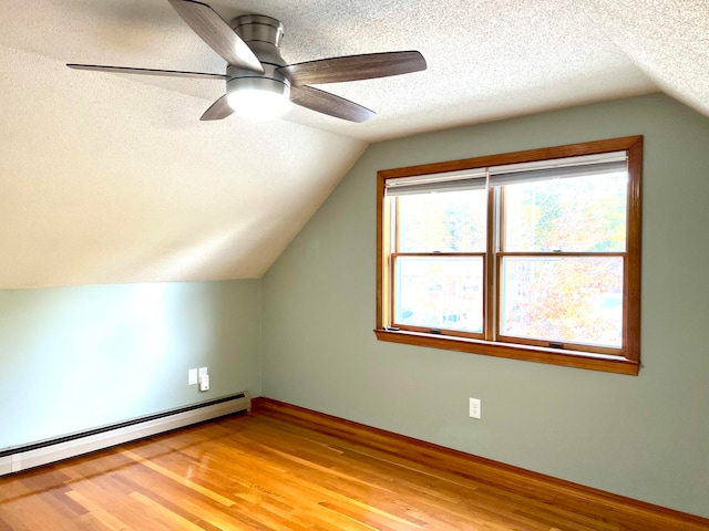 additional living space with ceiling fan, hardwood / wood-style flooring, a textured ceiling, and lofted ceiling