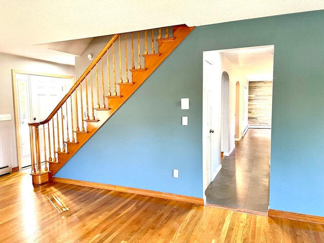 staircase featuring hardwood / wood-style floors and wooden walls