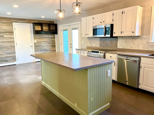 kitchen with pendant lighting, a kitchen island, white cabinets, and stainless steel appliances