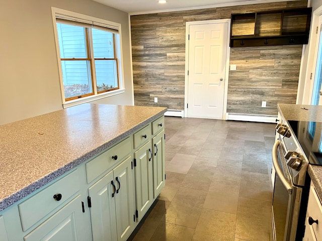 kitchen featuring a baseboard radiator, electric stove, green cabinetry, and wood walls