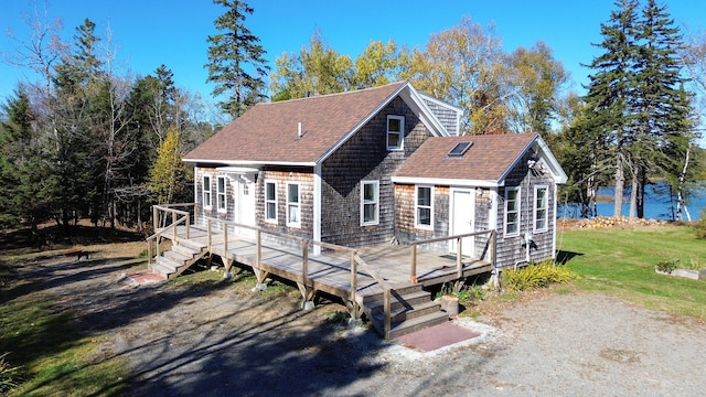 view of front facade featuring a deck with water view and a front yard