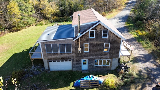 rear view of house with a yard and a garage