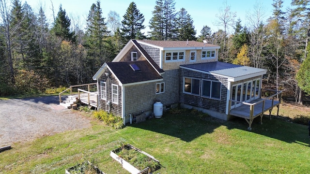 rear view of property with a wooden deck and a lawn