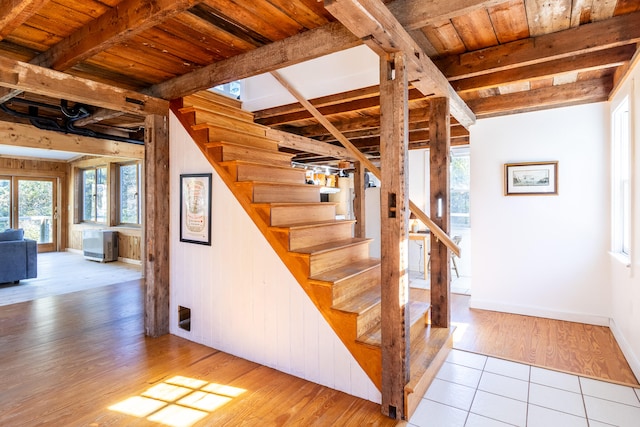 stairway with wood ceiling, hardwood / wood-style flooring, and beamed ceiling