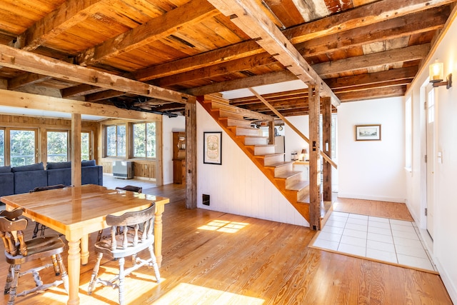 dining room with beam ceiling, light hardwood / wood-style flooring, and wooden ceiling