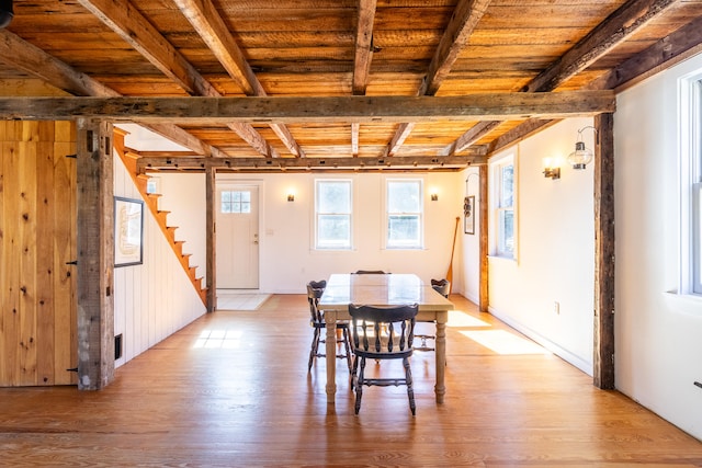 dining space with beam ceiling, wooden ceiling, and light wood-type flooring