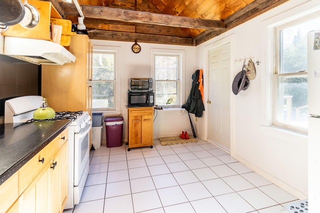 kitchen with white gas stove, light tile patterned flooring, hanging light fixtures, wooden ceiling, and beamed ceiling