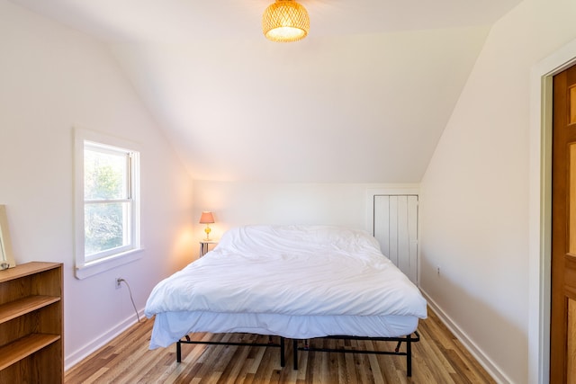 bedroom featuring vaulted ceiling and light wood-type flooring