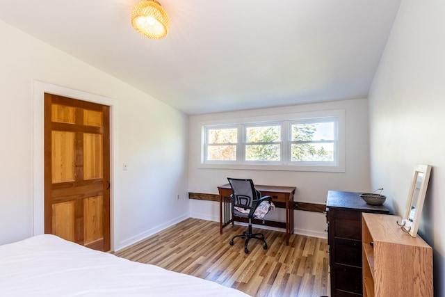 bedroom featuring light hardwood / wood-style floors and lofted ceiling