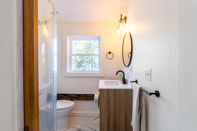 bathroom featuring vanity, toilet, and a shower with door