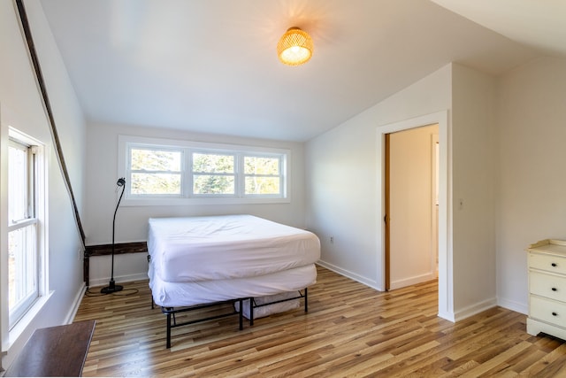 bedroom with light hardwood / wood-style flooring and vaulted ceiling