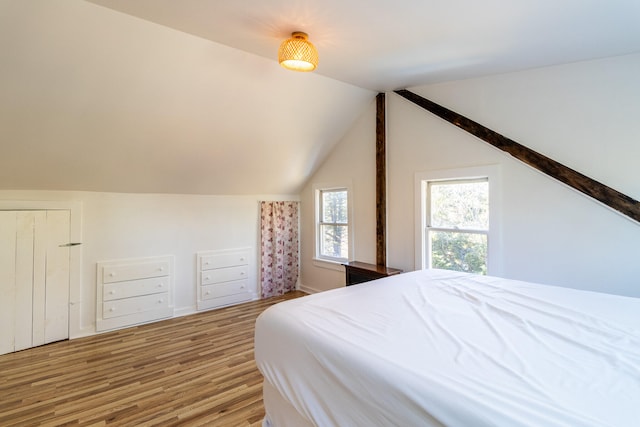 bedroom with light hardwood / wood-style floors and lofted ceiling