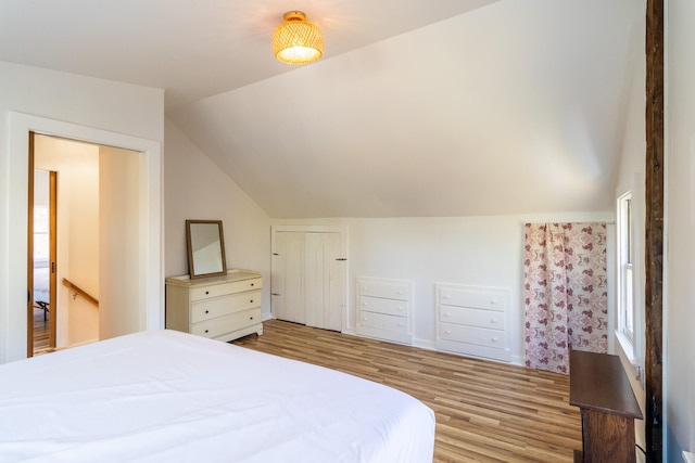 bedroom featuring vaulted ceiling, light hardwood / wood-style flooring, and a closet