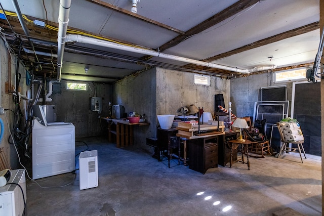 basement with gas water heater, electric panel, a wealth of natural light, and washing machine and clothes dryer