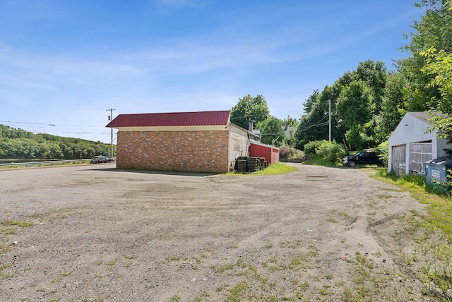 view of side of home with central AC and an outbuilding