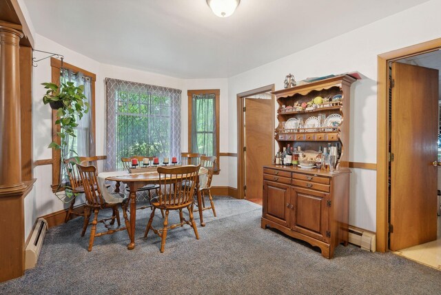 dining room featuring light carpet, a baseboard radiator, and decorative columns