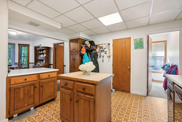 kitchen with a paneled ceiling and a kitchen island