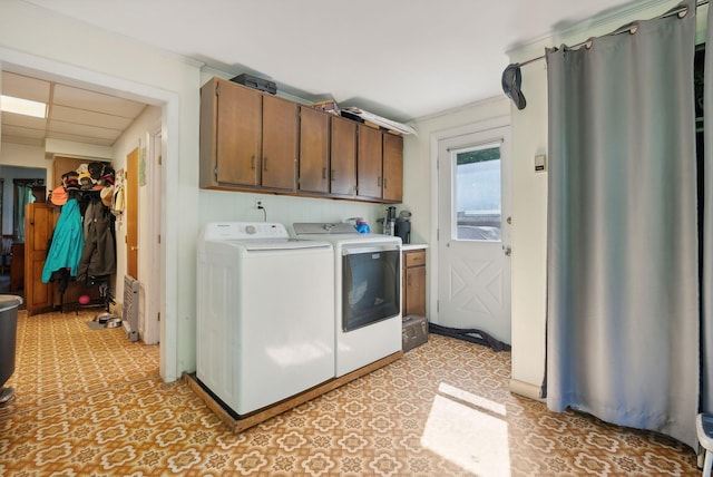 laundry room featuring crown molding, independent washer and dryer, and cabinets