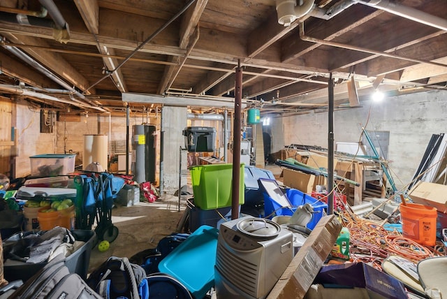 basement featuring electric water heater and water heater