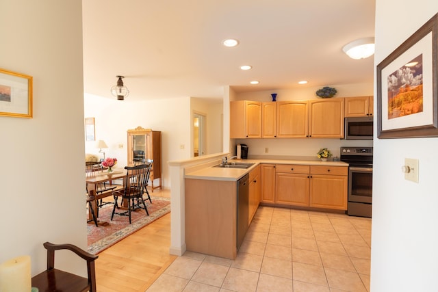 kitchen with appliances with stainless steel finishes, light countertops, a peninsula, light brown cabinets, and recessed lighting