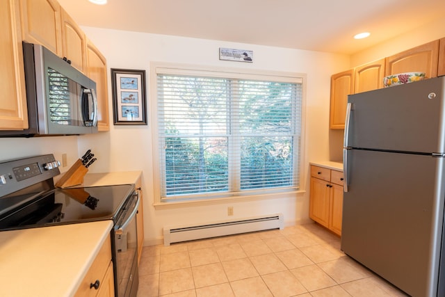 kitchen with light countertops, a baseboard heating unit, appliances with stainless steel finishes, and light brown cabinets