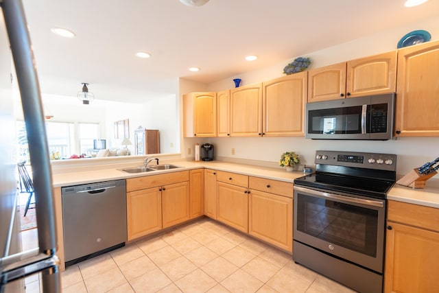 kitchen with light tile patterned flooring, appliances with stainless steel finishes, a sink, and light brown cabinets
