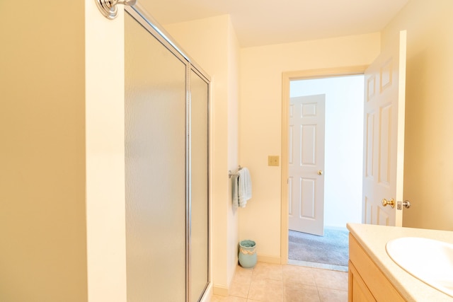 bathroom with vanity, baseboards, tile patterned flooring, and a stall shower