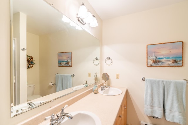 full bathroom with double vanity, toilet, and a sink