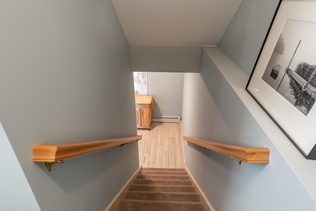 stairway with baseboards and a baseboard radiator