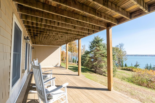 wooden deck featuring a lawn and a water view
