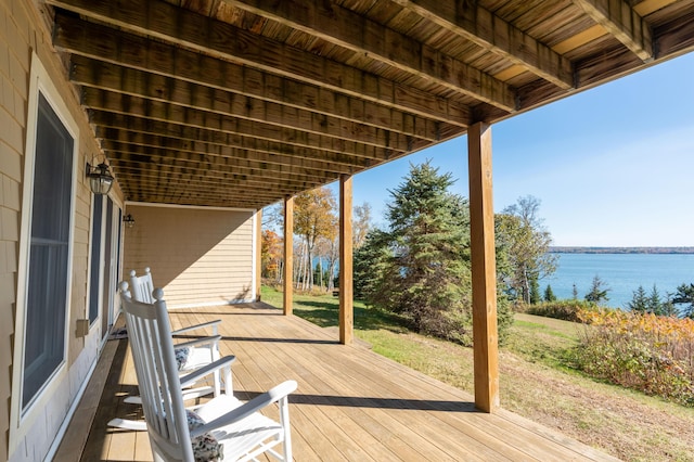 wooden terrace featuring a yard and a water view