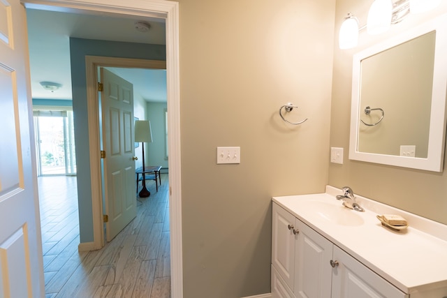 bathroom featuring vanity, baseboards, and wood finished floors