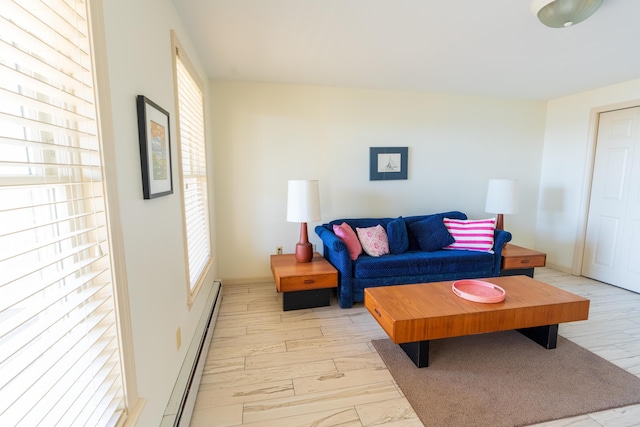 living area featuring light wood-type flooring, a healthy amount of sunlight, and a baseboard radiator