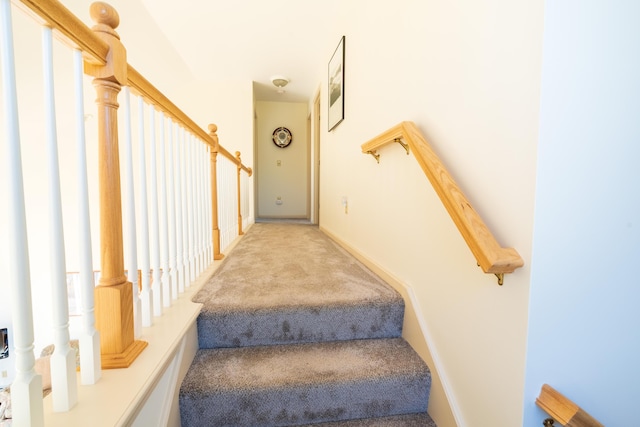 stairway featuring baseboards and carpet