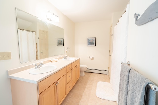 bathroom featuring double vanity, a baseboard radiator, a sink, and toilet