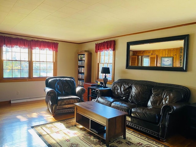 living room featuring baseboard heating, hardwood / wood-style floors, and crown molding