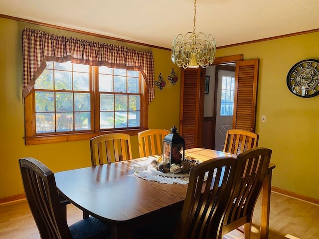 dining space featuring crown molding, a notable chandelier, and light hardwood / wood-style floors