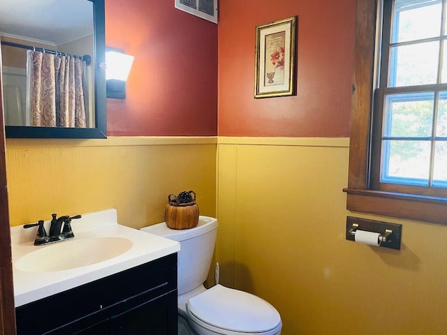 bathroom featuring a healthy amount of sunlight, vanity, and toilet