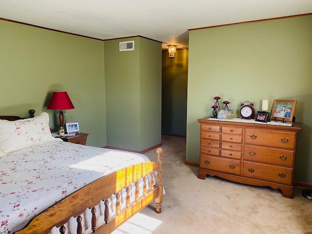 bedroom with ornamental molding and light colored carpet