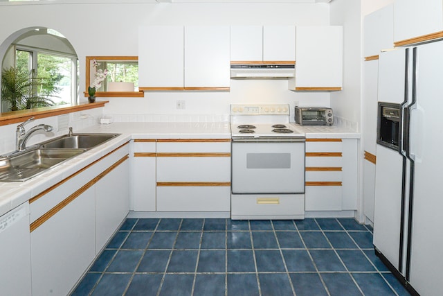 kitchen with white appliances, range hood, white cabinetry, and sink