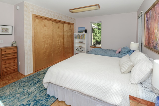 bedroom featuring parquet flooring and a closet