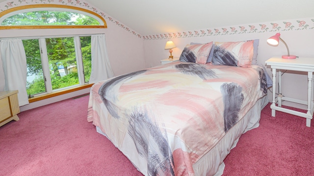 bedroom with vaulted ceiling and light colored carpet