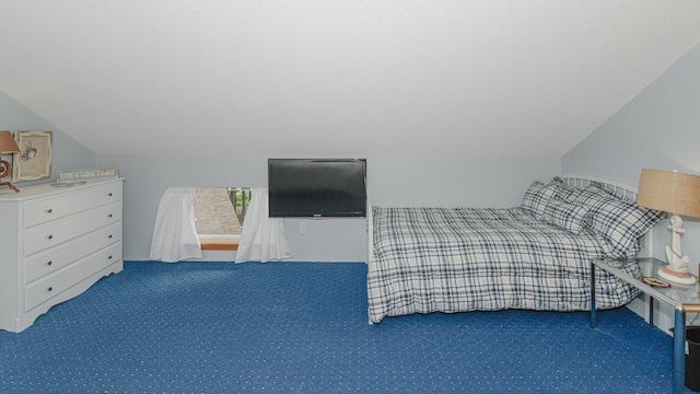 unfurnished bedroom with lofted ceiling and dark colored carpet