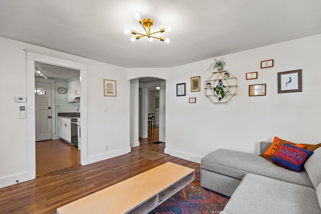 living room with dark wood-type flooring and a chandelier