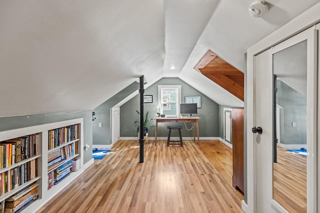 bonus room featuring light hardwood / wood-style floors, lofted ceiling, and built in shelves