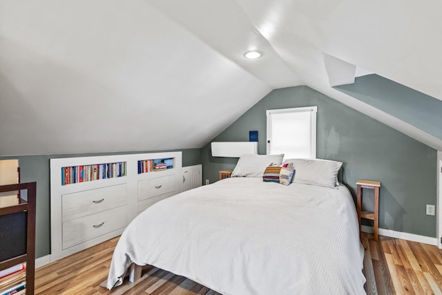 bedroom with vaulted ceiling and light hardwood / wood-style flooring