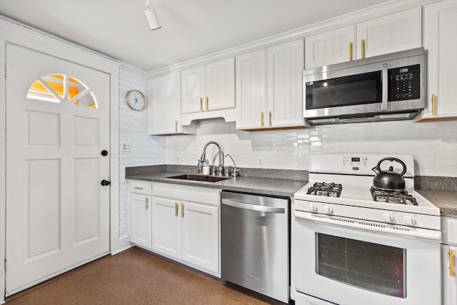 kitchen featuring stainless steel appliances, sink, white cabinets, and backsplash