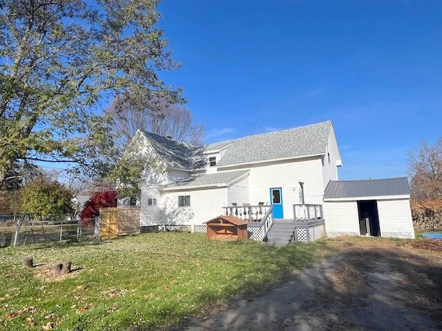 rear view of house featuring a deck and a lawn