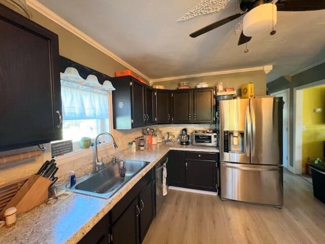 kitchen featuring stainless steel fridge, ornamental molding, sink, and tasteful backsplash