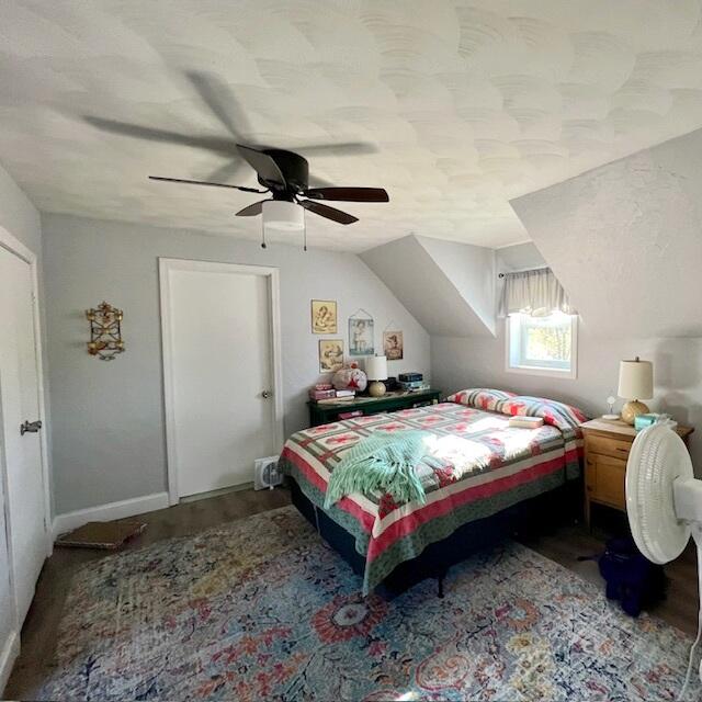 bedroom with vaulted ceiling, hardwood / wood-style flooring, and ceiling fan